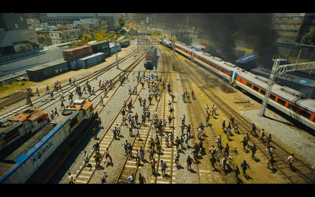 oster film Train to Busan menampilkan adegan ketegangan di dalam kereta yang penuh dengan zombie, dengan karakter utama Gong Yoo di tengah kekacauan.